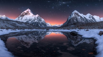 Majestic snow-capped mountains reflecting in a tranquil winter lake at dawn