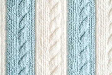 A textured background of a knitted garment with alternating light blue and white vertical cable stitch stripes.