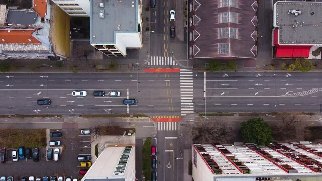 Aerial perspective of a Budapest road network, moving vehicles and crosswalks, top shot overview at intersection
