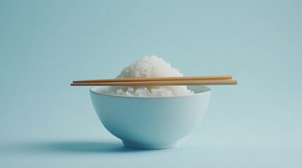 A bowl of fluffy white rice with chopsticks.