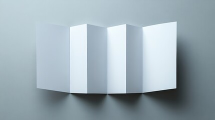 Fototapeta premium A blank paper brochure lies on a smooth grey surface, showcasing its clean and simple design. It is prepared for customization or printing, ideal for advertising purposes