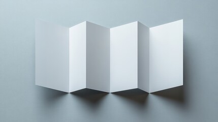 Fototapeta premium The image features blank folded paper set against a smooth, muted surface. The structure creates a clean, minimalistic look, emphasizing the beauty of simplicity and design