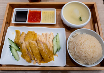 Hainanese Chicken Rice beautifully presented in a tray, serviced with three kinds of dipping sauce...