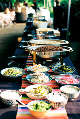 Colorful outdoor buffet of tacos with lots of dips, salsas and t