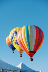 Fototapeta premium Colorful Hot Air Balloons Above Event Tents