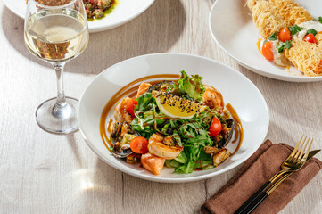 salad with seafood and arugula with lemon and sesame sauce
