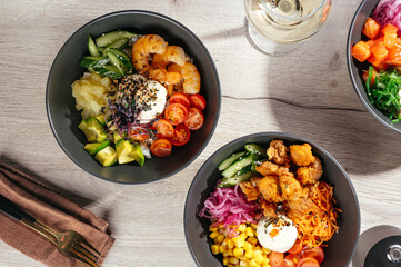 two poke bowls with wine on the table