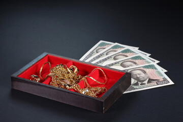 1万円札と金のジュエリー