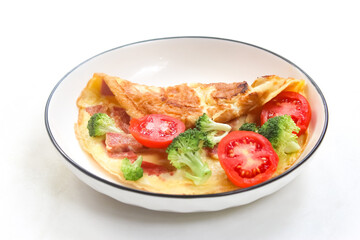 omelet with ham, tomato, broccoli in a plate isolated on white background