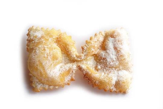 Italian traditional fried Crostoli or chiacchere or Bugie in shape of a bow or butterfly isolated on white background