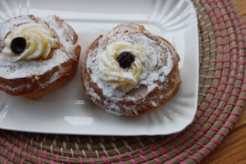 Two Italian fried Zeppole on a ceramic white tray for St. Joseph (Father’s day)