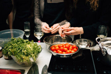 Cherry tomatoes, lettuce and the hands of chefs
