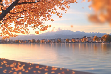 Scenic autumn lake view with golden leaves and a cityscape at sunset.