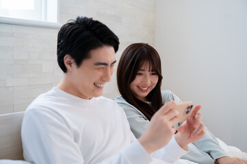 笑顔でスマホを見る日本人男女