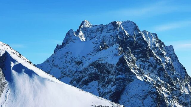 View of Dombay glaciers and mountain peaks in the winter sun. Panorama of the snow-capped Caucasus Mountains in sunny weather. Dombay-Ulgen and Moussa-Achitara mountains. Ski resort in Russia.