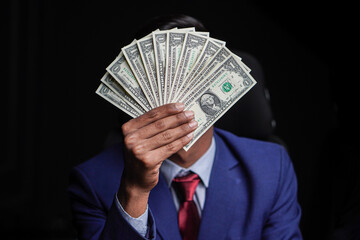 Businessman in suit holding American dollar notes in hands 