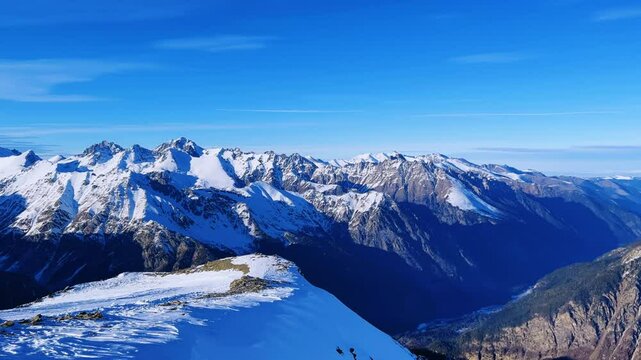 View of Dombay glaciers and mountain peaks in the winter sun. Panorama of the snow-capped Caucasus Mountains in sunny weather. Dombay-Ulgen and Moussa-Achitara mountains. Ski resort in Russia.