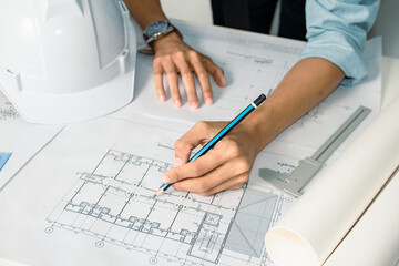 engineer designs a house blueprint in the office, drawing precise diagrams to plan a strong and safe structure for construction