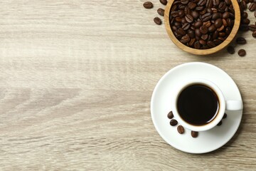 Cup of coffee and coffee beans on wooden background