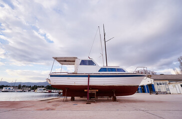 Fototapeta premium Sailboat in Dry Dock for Maintenance at Waterfront Harbor