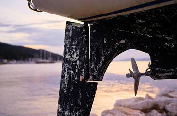 Fototapeta premium Rustic Boat Propeller Framed Against a Serene Waterscape at Sunset..