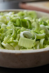 freshly sliced leek rings arranged in a white bowl, showcasing their vibrant green
