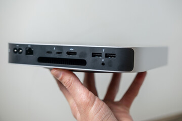 Mini computer held in male hands, ports portable computer, tech portability, working remotely in cozy home environment, home setup, remote job, downshifting lifestyle