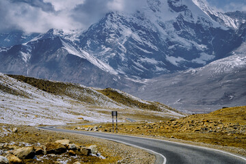 Long stretch of empty winding road with the majestic Himalayas in the backdrop at Sikkim, India  © Anshuman