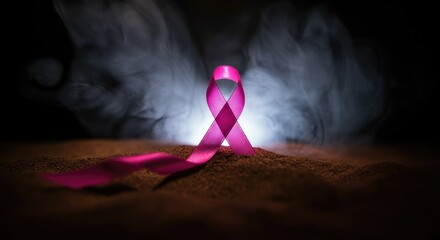 Pink ribbon symbolizing breast cancer awareness on misty background
