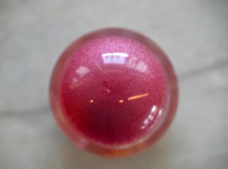 High resolution close up image of a single beautiful epoxy resin crystal ball filled with little rose quartz crystals and a large agate crystal in the center