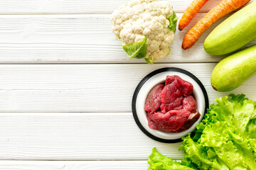 Bowls with healthy pet food and ingredients, top view