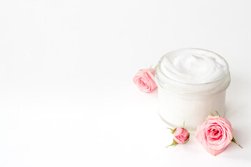 Closeup of pink roses and skin care cream with flowers essential oil