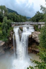 Fototapeta premium Majestic Waterfall Cascading Over Rocks Surrounded by Lush Greenery