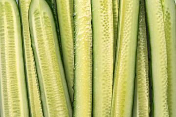Fresh juicy cucumber slices close-up, showcasing natural texture, freshness, water droplets, and healthy vegan food concept backdrop.
