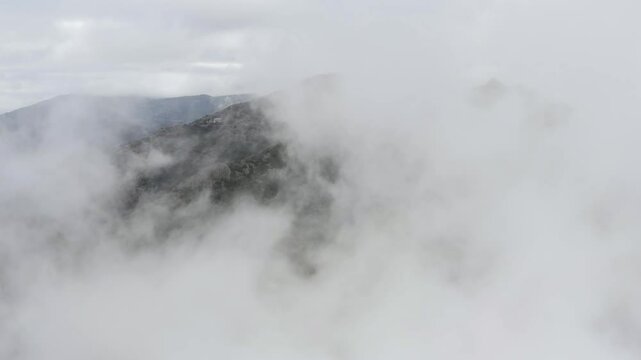 Spectacular view of clouds rolling over the rugged terrain of Troodos mountains, revealing the beauty and mystery of nature. Cyprus
