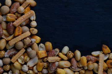 Variety of colorful snacks arranged artistically on a dark surface, showcasing texture and natural hues in an alluring composition