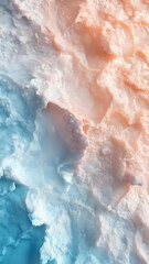 Fototapeta premium Abstract surface resembling soft terrain or whipped clouds, blending warm peach and icy blue tones. A dreamy phone wallpaper.