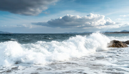 beautiful seascape featuring crashing waves against rocky shores, with dramatic clouds sky and distant mountains horizon. scene evokes sense