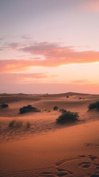 Sunset over sand dunes with footprints and stars