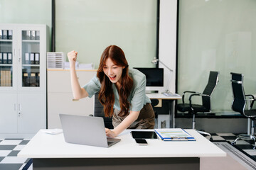 Asian business woman are delighted and happy with the work they do on their tablet, laptop and...