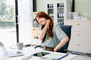 Obraz premium Overworked young Asian businesswoman office worker suffering from neck pain after had a long da
