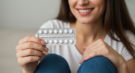 Woman in a floral shirt, smiling while holding two blister packs of pills, reflecting a sense of calm and preparedness.
