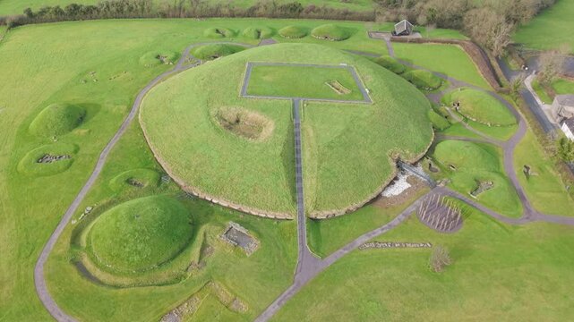 Knowth prehistoric site with grass-covered tombs and ancient passageways, aerial view