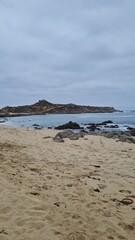Breathtaking view of Chile’s Pacific coast, featuring rugged rocks, golden sandy beach, and waves under a bright sky. Perfect for travel, nature, and coastal landscapes.