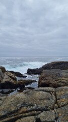 Breathtaking view of Chile’s Pacific coast, featuring rugged rocks, golden sandy beach, and waves under a bright sky. Perfect for travel, nature, and coastal landscapes.
