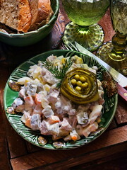Olivier salad and wine on wooden background