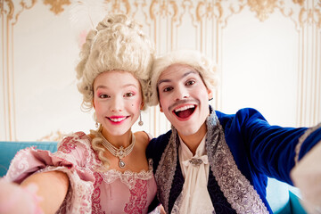 Elegant couple in baroque costumes enjoys a themed photoshoot against ornate interior details.