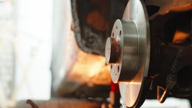 Skilled automotive technician performing brake disc replacement, wearing protective gear while maintaining vehicle safety standards in professional repair facility