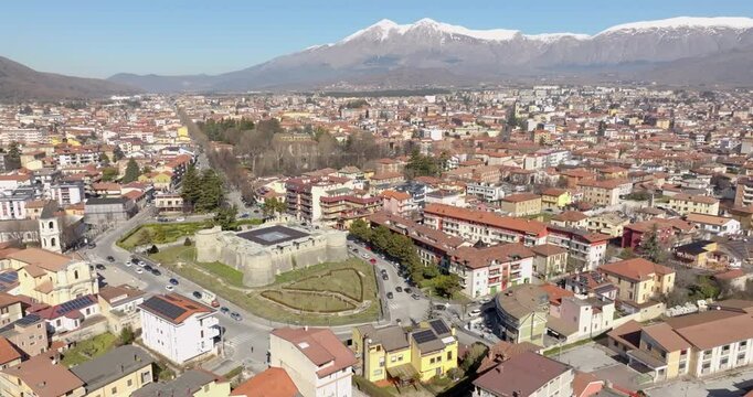 Aerial view of the Orsini-Colonna Castle, a fort located in the city of Avezzano, in Abruzzo, Italy. In the background are snow-capped mountains.