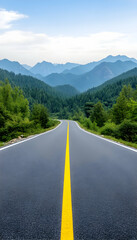 Scenic asphalt road disappearing into a mountainous landscape under a clear sky